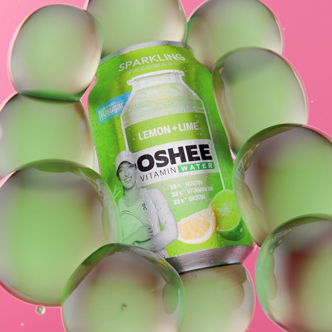 OSHEE Sparkling Vitamin Water lemon and lime can with no added sugar, tennis player Iga Świątek printed on the label, nested inside a cluster of translucent green bubbles on pink, 3D CGI product render