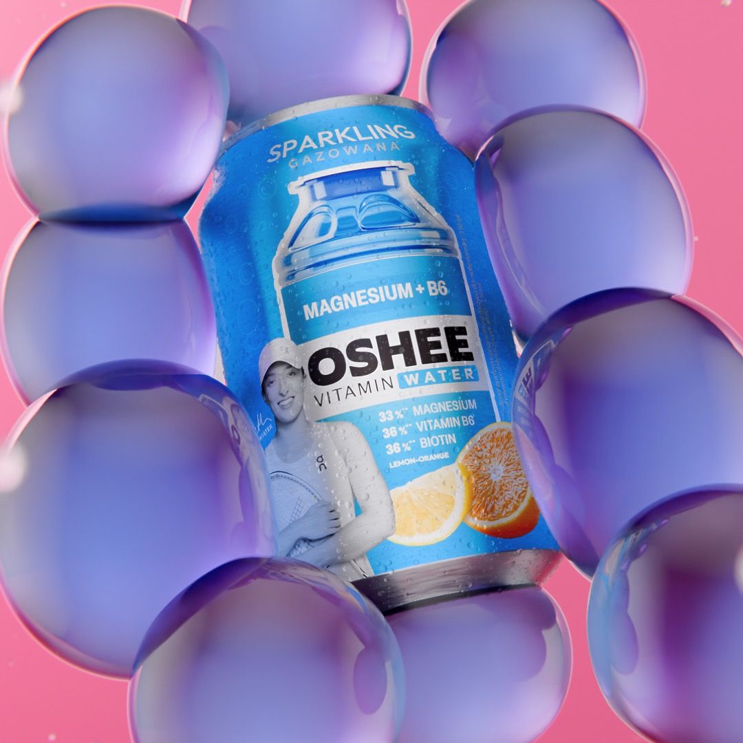OSHEE Sparkling Vitamin Water magnesium and B6 can in lemon-orange flavour, tennis player Iga Świątek printed on the label, nested inside a cluster of translucent violet bubbles on pink, 3D CGI product render