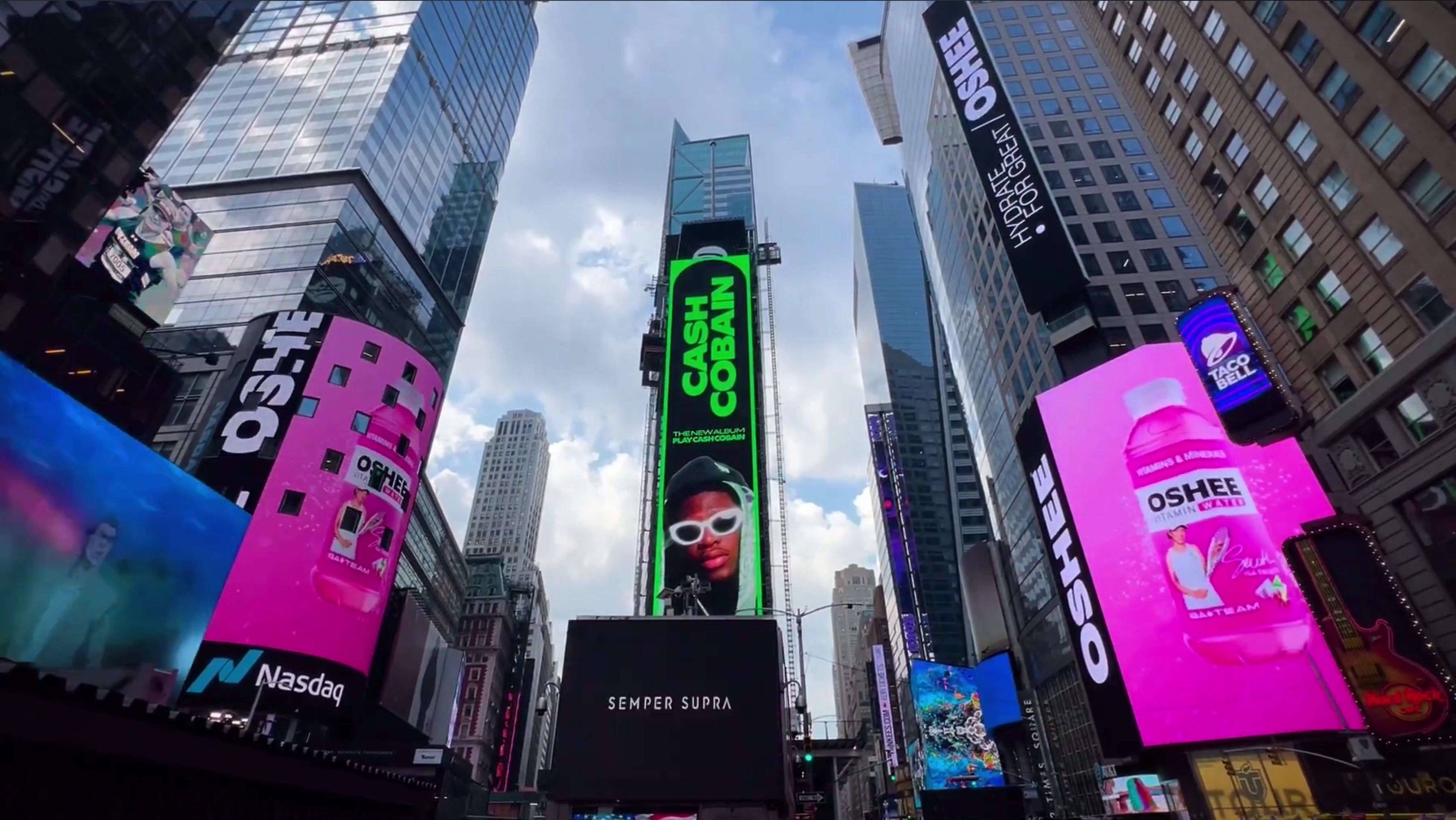OSHEE Vitamin Water campaign running on the big screens of Times Square, New York, two pink billboards showing the bottle above the Nasdaq tower