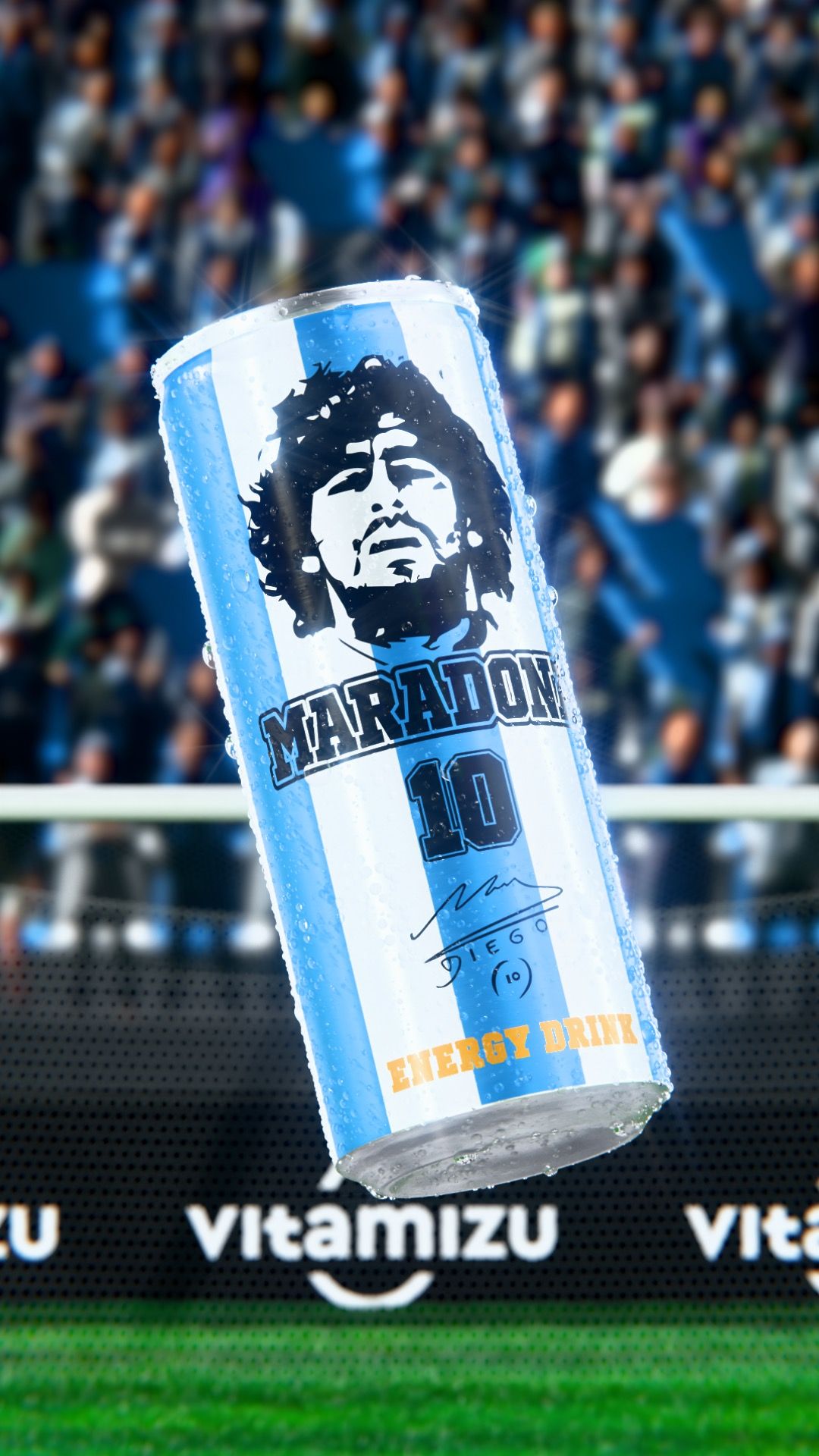 Single Vitamizu Maradona energy drink can with a stencilled Diego Maradona portrait and the number 10, floating above a stadium pitch with Vitamizu pitch-side branding and a blurred crowd, vertical 3D CGI product render